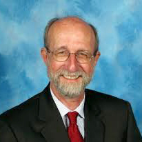 Portrait of a smiling man in a gray suit and red tie on a blue background